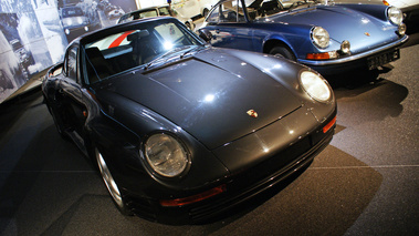 D'Ieteren Galerie - Porsche 959 noir & 911 bleu 3/4 avant droit penché
