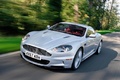 Aston Martin DBS gris 3/4 avant gauche travelling penché debout