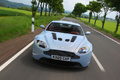 Aston Martin V12 Vantage bleu face avant travelling penché debout