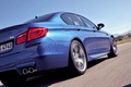 BMW M5 2011 bleu 3/4 arrière droit travelling penché coupé