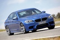 BMW M5 2011 bleu 3/4 avant droit penché