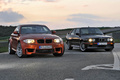BMW Série 1 M - orange - à côté d'une M3 MkII