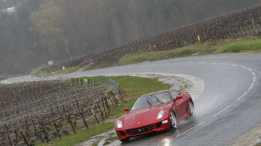 Ferrari 599 GTB Fiorano rouge vue 3/4 avant gauche sous la pluie.