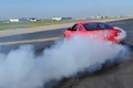 Ford Mustang GT rouge 3/4 arrière gauche penché burn