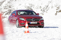 Mercedes CLS 4Matic - rouge - dans la neige, 3/4 avant droit, avec cône
