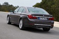 BMW 750Li MY2012 marron 3/4 arrière gauche travelling penché