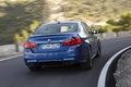 BMW M5 F10 bleu 3/4 arrière droit travelling penché
