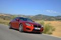 BMW M6 orange 3/4 avant droit travelling penché