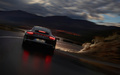 Porsche 991 Carrera 4S marron face arrière travelling penché