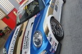 Porsche 997 GT3 RSR blanc/bleu 3/4 avant gauche penché debout